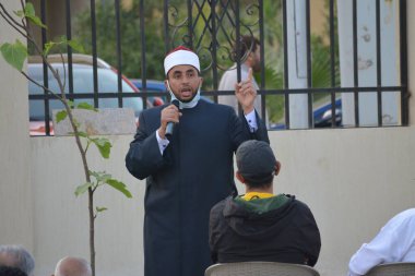 Kahire, Mısır, 2 Mayıs 2022: Bir cami vaizi, yaygınlık yasağı sona erdikten sonra cami yakınlarındaki açık hava sahasında Kurban İmam El Fitr Khutbah 'ı (vaaz) sahneledi, İslami kahvaltı namazı ve kutlama duası yaptı