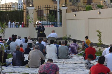 Kahire, Mısır, 2 Mayıs 2022: Bir cami vaizi, yaygınlık yasağı sona erdikten sonra cami yakınlarındaki açık hava sahasında Kurban İmam El Fitr Khutbah 'ı (vaaz) sahneledi, İslami kahvaltı namazı ve kutlama duası yaptı