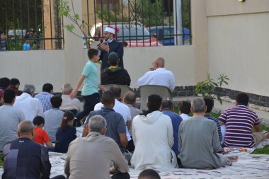 Kahire, Mısır, 2 Mayıs 2022: Bir cami vaizi, yaygınlık yasağı sona erdikten sonra cami yakınlarındaki açık hava sahasında Kurban İmam El Fitr Khutbah 'ı (vaaz) sahneledi, İslami kahvaltı namazı ve kutlama duası yaptı