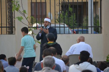 Kahire, Mısır, 2 Mayıs 2022: Bir cami vaizi, yaygınlık yasağı sona erdikten sonra cami yakınlarındaki açık hava sahasında Kurban İmam El Fitr Khutbah 'ı (vaaz) sahneledi, İslami kahvaltı namazı ve kutlama duası yaptı