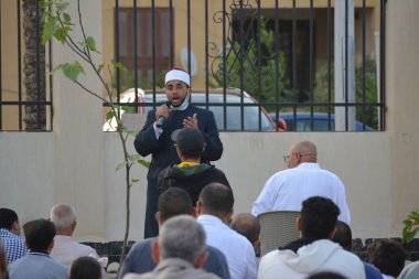 Kahire, Mısır, 2 Mayıs 2022: Bir cami vaizi, yaygınlık yasağı sona erdikten sonra cami yakınlarındaki açık hava sahasında Kurban İmam El Fitr Khutbah 'ı (vaaz) sahneledi, İslami kahvaltı namazı ve kutlama duası yaptı