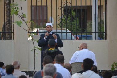 Kahire, Mısır, 2 Mayıs 2022: Bir cami vaizi, yaygınlık yasağı sona erdikten sonra cami yakınlarındaki açık hava sahasında Kurban İmam El Fitr Khutbah 'ı (vaaz) sahneledi, İslami kahvaltı namazı ve kutlama duası yaptı