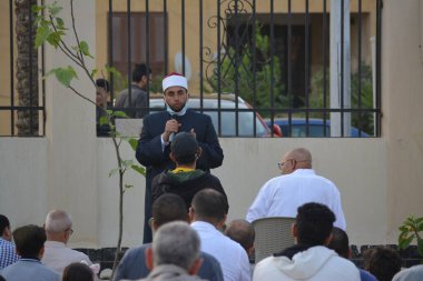 Kahire, Mısır, 2 Mayıs 2022: Bir cami vaizi, yaygınlık yasağı sona erdikten sonra cami yakınlarındaki açık hava sahasında Kurban İmam El Fitr Khutbah 'ı (vaaz) sahneledi, İslami kahvaltı namazı ve kutlama duası yaptı
