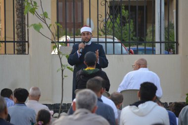 Kahire, Mısır, 2 Mayıs 2022: Bir cami vaizi, yaygınlık yasağı sona erdikten sonra cami yakınlarındaki açık hava sahasında Kurban İmam El Fitr Khutbah 'ı (vaaz) sahneledi, İslami kahvaltı namazı ve kutlama duası yaptı