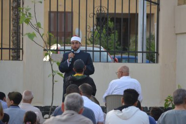 Kahire, Mısır, 2 Mayıs 2022: Bir cami vaizi, yaygınlık yasağı sona erdikten sonra cami yakınlarındaki açık hava sahasında Kurban İmam El Fitr Khutbah 'ı (vaaz) sahneledi, İslami kahvaltı namazı ve kutlama duası yaptı