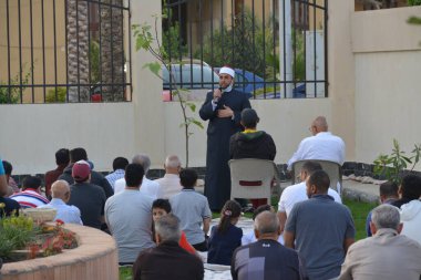 Kahire, Mısır, 2 Mayıs 2022: Bir cami vaizi, yaygınlık yasağı sona erdikten sonra cami yakınlarındaki açık hava sahasında Kurban İmam El Fitr Khutbah 'ı (vaaz) sahneledi, İslami kahvaltı namazı ve kutlama duası yaptı