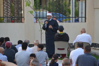 Kahire, Mısır, 2 Mayıs 2022: Bir cami vaizi, yaygınlık yasağı sona erdikten sonra cami yakınlarındaki açık hava sahasında Kurban İmam El Fitr Khutbah 'ı (vaaz) sahneledi, İslami kahvaltı namazı ve kutlama duası yaptı