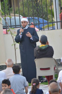 Kahire, Mısır, 2 Mayıs 2022: Bir cami vaizi, yaygınlık yasağı sona erdikten sonra cami yakınlarındaki açık hava sahasında Kurban İmam El Fitr Khutbah 'ı (vaaz) sahneledi, İslami kahvaltı namazı ve kutlama duası yaptı