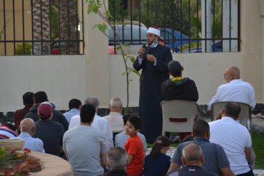 Kahire, Mısır, 2 Mayıs 2022: Bir cami vaizi, yaygınlık yasağı sona erdikten sonra cami yakınlarındaki açık hava sahasında Kurban İmam El Fitr Khutbah 'ı (vaaz) sahneledi, İslami kahvaltı namazı ve kutlama duası yaptı