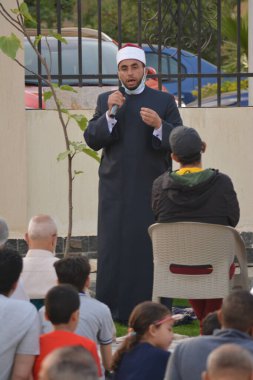 Kahire, Mısır, 2 Mayıs 2022: Bir cami vaizi, yaygınlık yasağı sona erdikten sonra cami yakınlarındaki açık hava sahasında Kurban İmam El Fitr Khutbah 'ı (vaaz) sahneledi, İslami kahvaltı namazı ve kutlama duası yaptı