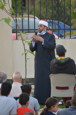 Kahire, Mısır, 2 Mayıs 2022: Bir cami vaizi, yaygınlık yasağı sona erdikten sonra cami yakınlarındaki açık hava sahasında Kurban İmam El Fitr Khutbah 'ı (vaaz) sahneledi, İslami kahvaltı namazı ve kutlama duası yaptı
