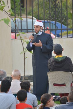 Kahire, Mısır, 2 Mayıs 2022: Bir cami vaizi, yaygınlık yasağı sona erdikten sonra cami yakınlarındaki açık hava sahasında Kurban İmam El Fitr Khutbah 'ı (vaaz) sahneledi, İslami kahvaltı namazı ve kutlama duası yaptı