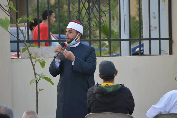 Kahire, Mısır, 2 Mayıs 2022: Bir cami vaizi, yaygınlık yasağı sona erdikten sonra cami yakınlarındaki açık hava sahasında Kurban İmam El Fitr Khutbah 'ı (vaaz) sahneledi, İslami kahvaltı namazı ve kutlama duası yaptı