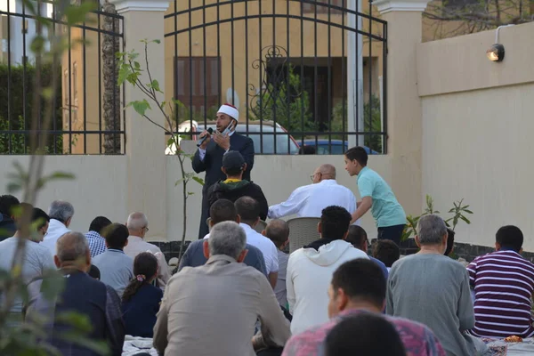 Kahire, Mısır, 2 Mayıs 2022: Bir cami vaizi, yaygınlık yasağı sona erdikten sonra cami yakınlarındaki açık hava sahasında Kurban İmam El Fitr Khutbah 'ı (vaaz) sahneledi, İslami kahvaltı namazı ve kutlama duası yaptı