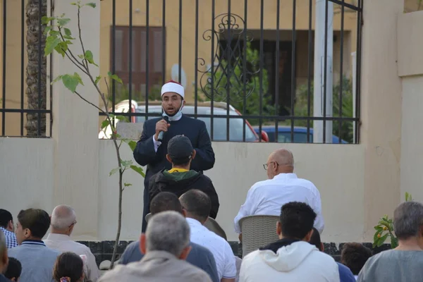 Kahire, Mısır, 2 Mayıs 2022: Bir cami vaizi, yaygınlık yasağı sona erdikten sonra cami yakınlarındaki açık hava sahasında Kurban İmam El Fitr Khutbah 'ı (vaaz) sahneledi, İslami kahvaltı namazı ve kutlama duası yaptı