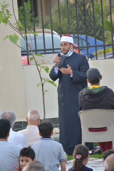 Kahire, Mısır, 2 Mayıs 2022: Bir cami vaizi, yaygınlık yasağı sona erdikten sonra cami yakınlarındaki açık hava sahasında Kurban İmam El Fitr Khutbah 'ı (vaaz) sahneledi, İslami kahvaltı namazı ve kutlama duası yaptı