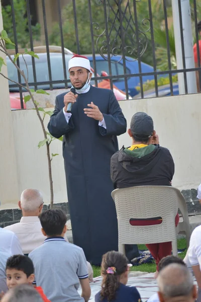 Kahire, Mısır, 2 Mayıs 2022: Bir cami vaizi, yaygınlık yasağı sona erdikten sonra cami yakınlarındaki açık hava sahasında Kurban İmam El Fitr Khutbah 'ı (vaaz) sahneledi, İslami kahvaltı namazı ve kutlama duası yaptı