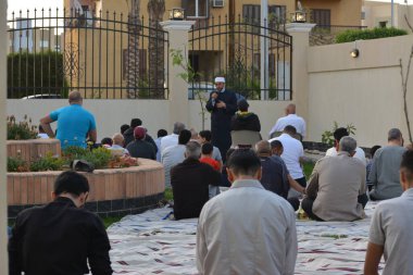 Kahire, Mısır, 2 Mayıs 2022: Bir cami vaizi, yaygınlık yasağı sona erdikten sonra cami yakınlarındaki açık hava sahasında Kurban İmam El Fitr Khutbah 'ı (vaaz) sahneledi, İslami kahvaltı namazı ve kutlama duası yaptı