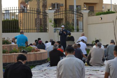 Kahire, Mısır, 2 Mayıs 2022: Bir cami vaizi, yaygınlık yasağı sona erdikten sonra cami yakınlarındaki açık hava sahasında Kurban İmam El Fitr Khutbah 'ı (vaaz) sahneledi, İslami kahvaltı namazı ve kutlama duası yaptı