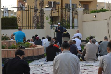 Kahire, Mısır, 2 Mayıs 2022: Bir cami vaizi, yaygınlık yasağı sona erdikten sonra cami yakınlarındaki açık hava sahasında Kurban İmam El Fitr Khutbah 'ı (vaaz) sahneledi, İslami kahvaltı namazı ve kutlama duası yaptı