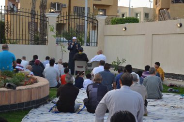 Kahire, Mısır, 2 Mayıs 2022: Bir cami vaizi, yaygınlık yasağı sona erdikten sonra cami yakınlarındaki açık hava sahasında Kurban İmam El Fitr Khutbah 'ı (vaaz) sahneledi, İslami kahvaltı namazı ve kutlama duası yaptı