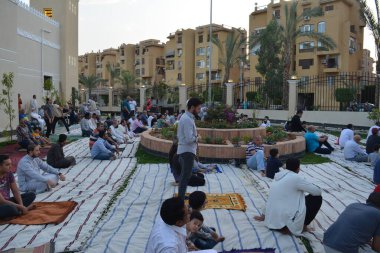 Kahire, Mısır, 2 Mayıs 2022: Mısır 'daki Müslümanlar, pandemik yasak sona erdikten sonra cami yakınlarındaki açık hava sahasında Kurban Bayramı dini ayinleri düzenledi, İslami kahvaltı duaları ve kutlamalar yapıldı