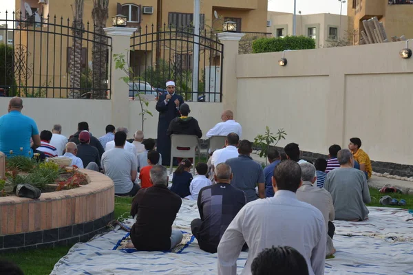 Kahire, Mısır, 2 Mayıs 2022: Bir cami vaizi, yaygınlık yasağı sona erdikten sonra cami yakınlarındaki açık hava sahasında Kurban İmam El Fitr Khutbah 'ı (vaaz) sahneledi, İslami kahvaltı namazı ve kutlama duası yaptı