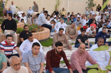 Kahire, Mısır, 2 Mayıs 2022: Mısır 'daki Müslümanlar, pandemik yasak sona erdikten sonra cami yakınlarındaki açık hava sahasında Kurban Bayramı dini ayinleri düzenledi, İslami kahvaltı duaları ve kutlamalar yapıldı