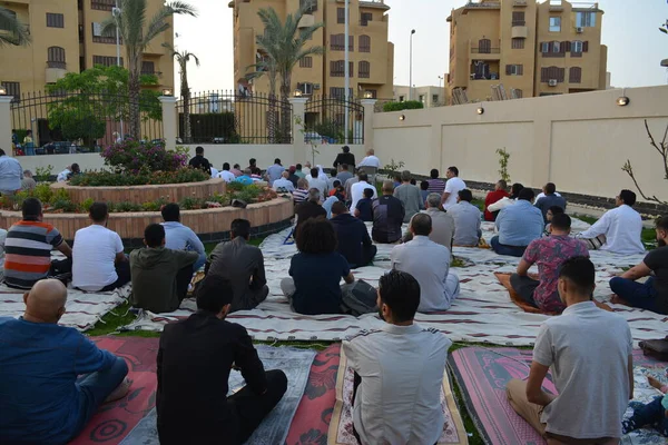 Cairo, Egypt, May 2 2022: Muslims in Egypt perform Eid Al Fitr religious rituals in the open air space near the mosque after pandemic ban is ended, Islamic breakfast feast prayers and celebration