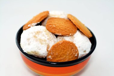 El-Fitr bayramı, Mısır Bisküvileri ve Kahk 'ın pudra şekerle kaplanıp fındık ve Malban izolasyonuyla doldurulmasını kutlamak için geleneksel Arap kurabiyelerinden oluşan derin bir tabak.