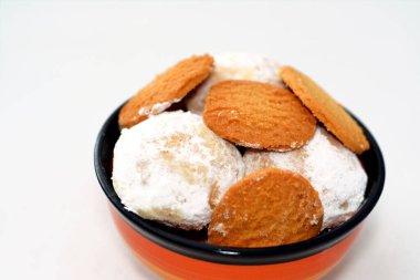 El-Fitr bayramı, Mısır Bisküvileri ve Kahk 'ın pudra şekerle kaplanıp fındık ve Malban izolasyonuyla doldurulmasını kutlamak için geleneksel Arap kurabiyelerinden oluşan derin bir tabak.