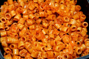 Lezzetli, iştah açıcı klasik makarna halkaları domates soslu makarna, sarımsak, soğan, baharat, yağ ve karabiber.