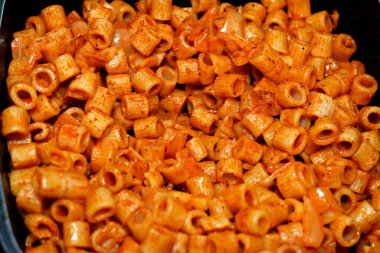 Lezzetli, iştah açıcı klasik makarna halkaları domates soslu makarna, sarımsak, soğan, baharat, yağ ve karabiber.