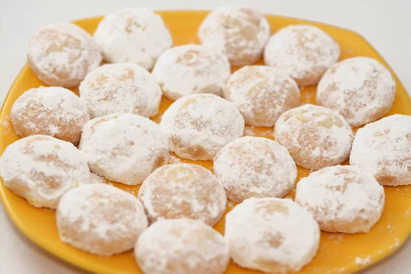 伝統的なアラビアクッキーの黄色のプレートエル フィトルの祝日を祝うために エジプトのカークは粉砂糖と詰め物のナッツとヘーゼルナッツで覆われ マルバンは白で隔離されました — ストック写真