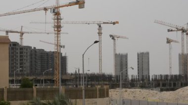 Giza, Egypt, May 13 2022: Construction site of new buildings in Egypt, Zed city Sheikh Zayed city, acres of luxurious real estate residential buildings under construction with cranes, selective focus