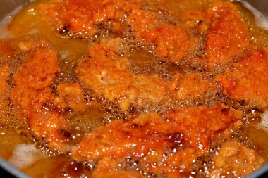 Yağlı arka planda kızarmış tavuk şeritleri, tavuk parmakları, fileto, goujonlar göğüs kemiğinin her iki tarafından gelen beyaz tavuk etidir.