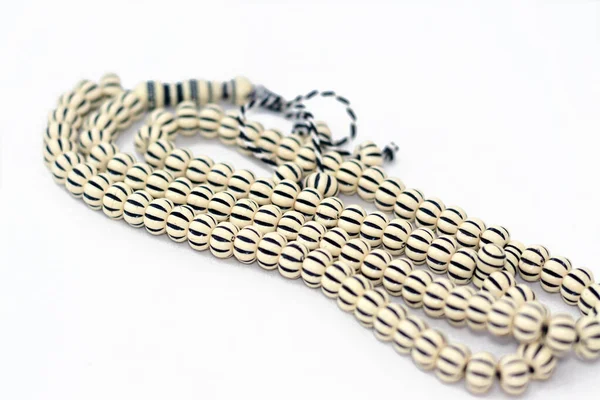 Müslümanların Allah 'a şükretmek için kullandığı 99 tespih ve siyah çizgili İslami tespih duası. Cümleleri kullanarak Allah' ı övmek ve övmek gibi. En büyük, en seçici odak noktası.