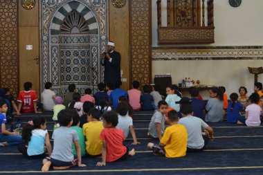 Kahire, Mısır, 31 Mayıs 2022: Cami vaizi İmam, camideki çocuklara yönelik yaz İslami eğitim programı sırasında camide genç Müslüman çocuklara vaaz veriyor.