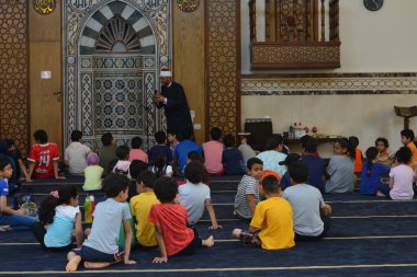 Kahire, Mısır, 31 Mayıs 2022: Cami vaizi İmam, camideki çocuklara yönelik yaz İslami eğitim programı sırasında camide genç Müslüman çocuklara vaaz veriyor.