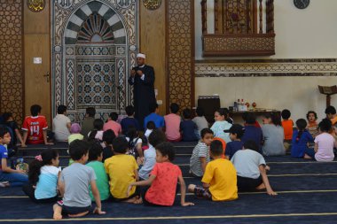 Kahire, Mısır, 31 Mayıs 2022: Cami vaizi İmam, camideki çocuklara yönelik yaz İslami eğitim programı sırasında camide genç Müslüman çocuklara vaaz veriyor.