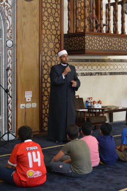 Kahire, Mısır, 31 Mayıs 2022: Cami vaizi İmam, camideki çocuklara yönelik yaz İslami eğitim programı sırasında camide genç Müslüman çocuklara vaaz veriyor.