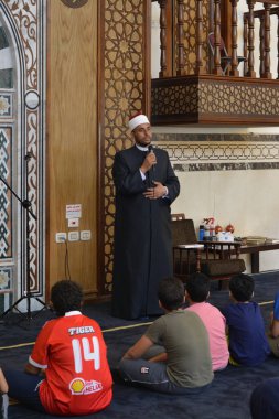 Kahire, Mısır, 31 Mayıs 2022: Cami vaizi İmam, camideki çocuklara yönelik yaz İslami eğitim programı sırasında camide genç Müslüman çocuklara vaaz veriyor.