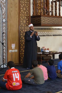Kahire, Mısır, 31 Mayıs 2022: Cami vaizi İmam, camideki çocuklara yönelik yaz İslami eğitim programı sırasında camide genç Müslüman çocuklara vaaz veriyor.