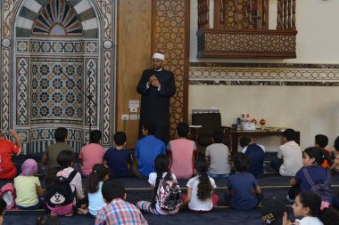 Kahire, Mısır, 31 Mayıs 2022: Cami vaizi İmam, camideki çocuklara yönelik yaz İslami eğitim programı sırasında camide genç Müslüman çocuklara vaaz veriyor.