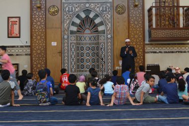 Kahire, Mısır, 31 Mayıs 2022: Cami vaizi İmam, camideki çocuklara yönelik yaz İslami eğitim programı sırasında camide genç Müslüman çocuklara vaaz veriyor.