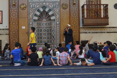 Kahire, Mısır, 31 Mayıs 2022: Cami vaizi İmam, camideki çocuklara yönelik yaz İslami eğitim programı sırasında camide genç Müslüman çocuklara vaaz veriyor.