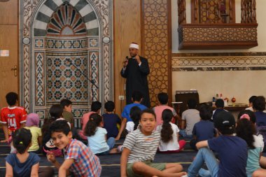 Kahire, Mısır, 31 Mayıs 2022: Cami vaizi İmam, camideki çocuklara yönelik yaz İslami eğitim programı sırasında camide genç Müslüman çocuklara vaaz veriyor.