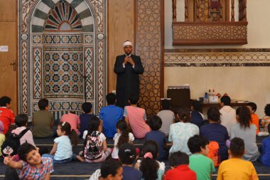 Kahire, Mısır, 31 Mayıs 2022: Cami vaizi İmam, camideki çocuklara yönelik yaz İslami eğitim programı sırasında camide genç Müslüman çocuklara vaaz veriyor.