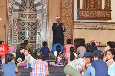 Kahire, Mısır, 31 Mayıs 2022: Cami vaizi İmam, camideki çocuklara yönelik yaz İslami eğitim programı sırasında camide genç Müslüman çocuklara vaaz veriyor.