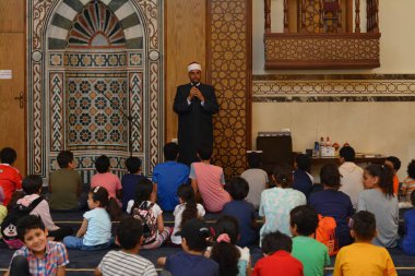 Kahire, Mısır, 31 Mayıs 2022: Cami vaizi İmam, camideki çocuklara yönelik yaz İslami eğitim programı sırasında camide genç Müslüman çocuklara vaaz veriyor.